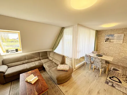 offener Wohnbereich mit Eckcouch, ein Sessel, Stehlampe, Sessel, Couchtisch, 48 Zoll Smart-TV, Hifi Microanlage mit CD-Player, MP3, UKW-Funktion, USB und Bluetooth mit NFC und ein DAB-Radio