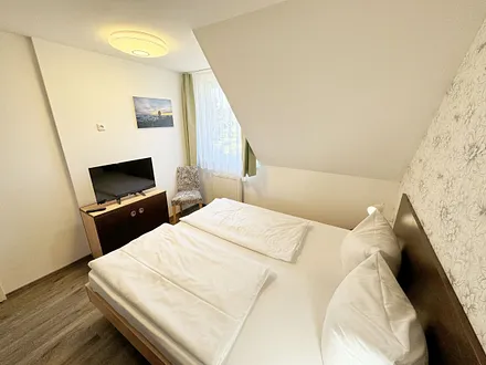 Schlafzimmer mit Doppelbett ( 2 x 0,90 m x 2,00 m ), Nachttischablagen mit Leselampen, 17 Zoll LED-TV, Kleiderschrank mit Safe, Sideboard, Verdunklungsgardinen sowie Insektenschutzgitter