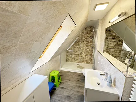 Badzimmer mit ebenerdiger Dusche (1,70 m x 0,90 m), WC, Waschtisch, Fön, großer Wandspiegel, Handtuchheizkörper und Ablageregal