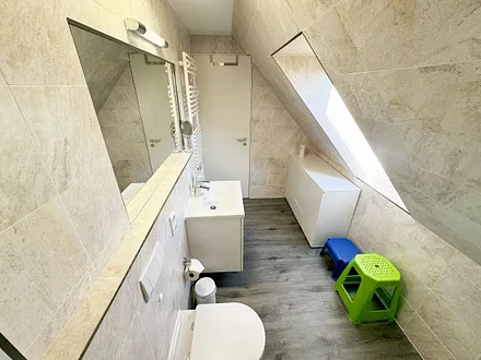 Badzimmer mit ebenerdiger Dusche (1,70 m x 0,90 m), WC, Waschtisch, Fön, großer Wandspiegel, Handtuchheizkörper und Ablageregal