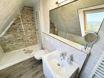 Badzimmer mit ebenerdiger Dusche (1,70 m x 0,90 m), WC, Waschtisch, Fön, großer Wandspiegel, Handtuchheizkörper und Ablageregal