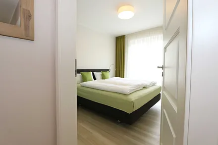 Schlafzimmer mit großem Schwebetürenschrank, bequemen Boxspringbett von Hülsta (1,80 m x 2,00 m, durchgehender Topper), Nachttischablagen und Leselampen