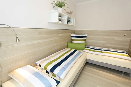 Schlafzimmer mit zwei übereckstehenden Betten (0,80 m x 2,00 m), Leselampen, diversen Ablagemöglichkeiten und zwei kleinen Schränken