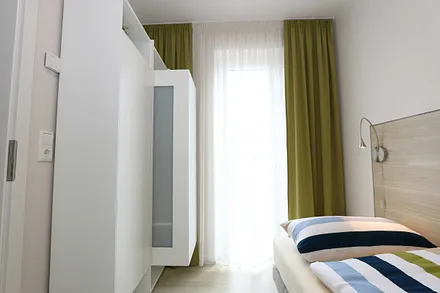 Schlafzimmer mit zwei übereckstehenden Betten (0,80 m x 2,00 m), Leselampen, diversen Ablagemöglichkeiten und zwei kleinen Schränken