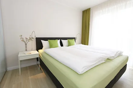Schlafzimmer mit großem Schwebetürenschrank, bequemen Boxspringbett von Hülsta (1,80 m x 2,00 m, durchgehender Topper), Nachttischablagen und Leselampen