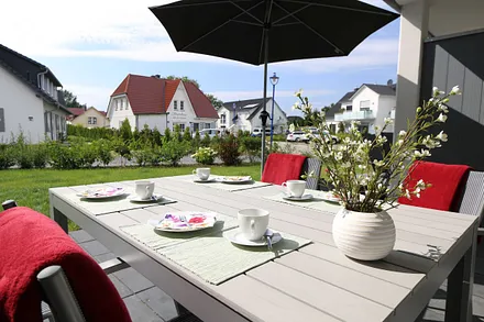 große bestuhlte Terrasse (West) mit Sonnenschirm und Relaxsessel