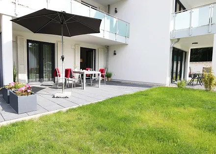 große bestuhlte Terrasse (West) mit Sonnenschirm und Relaxsessel