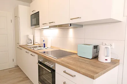 Küchenzeile mit Kühlschrank und Gefrierfach, Geschirrspüler, 4 Zonen Ceranfeld mit Backofen, Mikrowelle, Kaffeemaschine, Wasserkocher, Toaster, Mixer sowie diversen Küchenutensilien