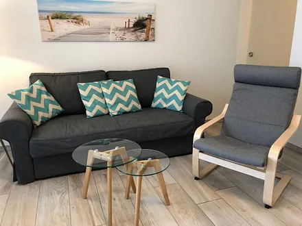 Wohnbereich mit Couch (voll funktionstüchtiges Bett mit Lattenrost und Matratze - Liegefläche 1,60 m x 2,00 m),Couchtisch,Sideboard,Leselampe,Flachbild-TV mit  Blu-Ray Player & Micro-Hifi System