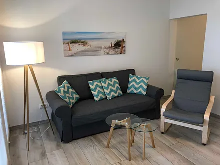 Wohnbereich mit Couch (voll funktionstüchtiges Bett mit Lattenrost und Matratze - Liegefläche 1,60 m x 2,00 m),Couchtisch,Sideboard,Leselampe,Flachbild-TV mit  Blu-Ray Player & Micro-Hifi System