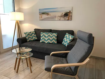 Wohnbereich mit Couch (voll funktionstüchtiges Bett mit Lattenrost und Matratze - Liegefläche 1,60 m x 2,00 m),Couchtisch,Sideboard,Leselampe,Flachbild-TV mit  Blu-Ray Player & Micro-Hifi System