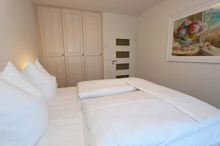 Schlafzimmer  im Landhausstil mit großem Doppelbett (1,60 m x 2,00 m), 5-Zonen-Federkern-Matratzen, verstellbare Lattenroste, Nackenkissen, Nachttischablagen und geräumigen Einbauschrank