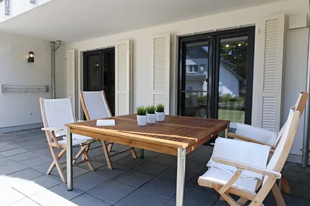 direkter Zugang zur Südwestterrasse, ausgestattet mit großem Tisch und Teakmöbeln