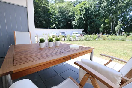 direkter Zugang zur Südwestterrasse, ausgestattet mit großem Tisch und Teakmöbeln