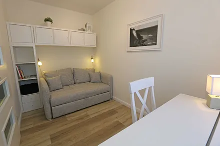 Schlafzimmer mit Funktionssofa (ausziehbare Liegefläche von 1,40 m x 2,00 m), umrahmt von Hängeschränke sowie einem Schreibtisch