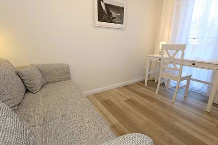 Schlafzimmer mit Funktionssofa (ausziehbare Liegefläche von 1,40 m x 2,00 m), umrahmt von Hängeschränke sowie einem Schreibtisch