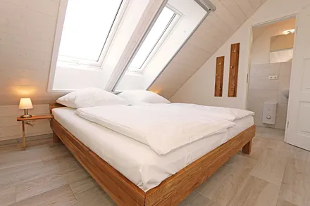 Schlafzimmer mit Doppelbett (1,80 m x 2,00 m), Nachttischablagen, Kleiderschrank und En Suite Badezimmer mit WC, Waschplatz, Fön und Dusche