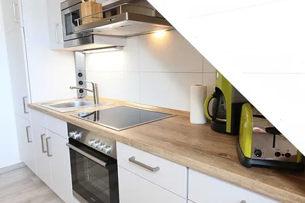 Küchenzeile mit Geschirrspüler, Backofen, 4 Zonen-Cerankochfeld, Kühlschrank mit Gefrierkombination, Kaffeemaschine, Mikrowelle, Toaster, Wasserkocher und vielen Küchenhelfern