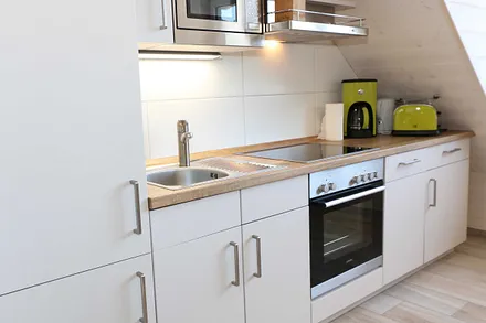 Küchenzeile mit Geschirrspüler, Backofen, 4 Zonen-Cerankochfeld, Kühlschrank mit Gefrierkombination, Kaffeemaschine, Mikrowelle, Toaster, Wasserkocher und vielen Küchenhelfern