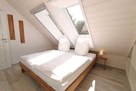 Schlafzimmer mit Doppelbett (1,80 m x 2,00 m), Nachttischablagen, Kleiderschrank und En Suite Badezimmer mit WC, Waschplatz, Fön und Dusche