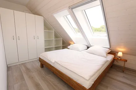 Schlafzimmer mit Doppelbett (1,80 m x 2,00 m), Nachttischablagen, Kleiderschrank und En Suite Badezimmer mit WC, Waschplatz, Fön und Dusche