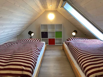 Schlafzimmer mit Doppelbett (1,80 m x 2,00 m), Nachttischablagen und Kleiderschrank