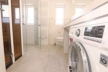 Tageslichtbad mit Infrarotsauna, Wasch- und Trockenautomat, WC, Waschtisch, Fön sowie eine Dusche