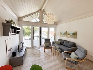 gemütliches Wohnzimmer mit Couch und Smart-TV