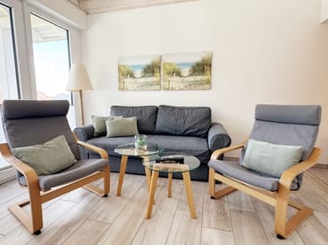 gemütliches Wohnzimmer mit Couch und Sessel