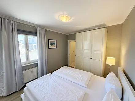 Schlafzimmer mit Doppelbett und Kleiderschrank