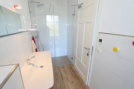 kleines Bad mit bodengleicher Dusche, WC und Waschtisch