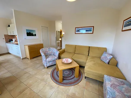 Wohnbereich mit Eckcouch, Couchtisch, Sessel, LCD-TV und ein Radio mit CD-Player