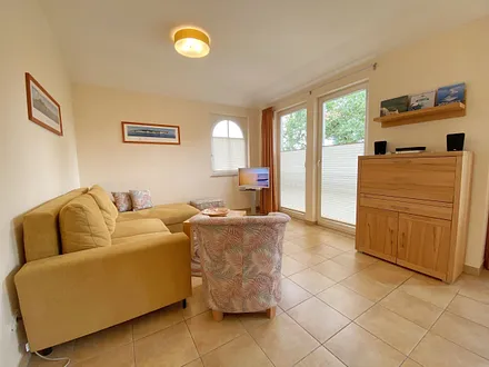 Wohnbereich mit Eckcouch, Couchtisch, Sessel, LCD-TV und ein Radio mit CD-Player