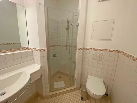 Badezimmer mit Anti-Rutsch-Fliesen, Waschtisch, gemauerte Eckdusche mit hochwertigen Armaturen, WC und beheizbarer Design-Handtuchhalter