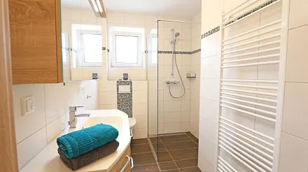 Tageslichtbad mit Walk-In-Dusche, 1 Waschtisch mit Unterschränken und Spiegelschrank, WC, Handtuchtrockner, Haarfön