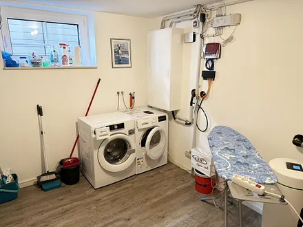 allgemeiner Wirtschaftsraum mit Entkalkungsanlage, Waschmaschine, Trockner, Wäscheständer, Bügelbrett und Bügeleisen zur kostenfreien Nutzung