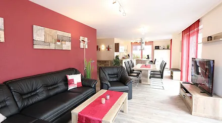 Wohnbereich mit Ledergarnitur, Elektrokamin, Sideboard, Leselampe, Stereoanlage mit USB und Bluetooth, TV-Lowboard mit 55 Zoll Smart-TV inklusive Full-HD, Sky