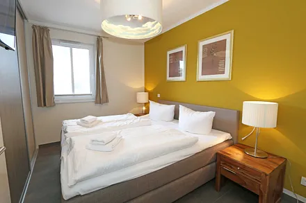 Schlafzimmer mit einem Boxspringbett (1,80 m x 2,00 m), Smart-TV, Nachttischschränken und einen Kleiderschrank