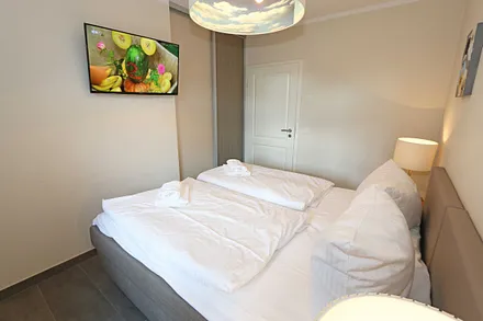 Schlafzimmer mit zwei einzelnen Boxspringbetten (0,90 m x 2,00 m, die Betten sind hier mit Rollen versehen und zusammenschiebbar), Nachttischschränken, Flachbild-TV und einen Kleiderschrank
