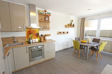 Küchenzeile mit Induktionsfeld, Backofen, Geschirrspüler, Kühlschrank mit Gefrierfach, Kaffeemaschine, Wasserkocher, Toaster und diversen Küchenutensilien