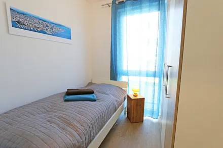 Schlafzimmer ein Einzelbett (0,90 m x 2,00 m), Nachttischablage und Kleiderschrank