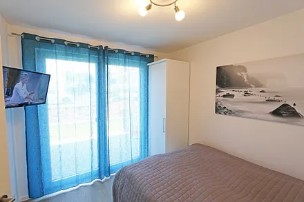 Schlafzimmer mit Doppelbett und Kaltschaummatratze (1,60 m x 2,00 m/ H3), Nachttischablagen, Smart-TV und Kleiderschrank