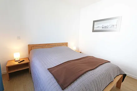 Schlafzimmer mit Doppelbett und Kaltschaummatratze (1,60 m x 2,00 m/ H3), Nachttischablagen, Smart-TV und Kleiderschrank