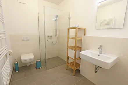 2 Bäder mit ebenerdigen Duschen, Waschplatz, Kosmetikspiegel, Fön, WC und Handtuchheizkörper sowie eine Waschmaschine