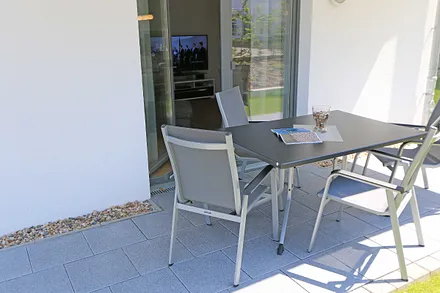 überdachte und bestuhlte Terrasse (West) mit Sonnenschirm - vom Wohn- und einem Schlafzimmer aus erreichbar