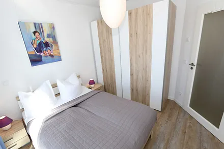 Schlafzimmer mit Doppelbett und durchgehender Kaltschaummatratze (1,40 m x 2,00 m), Nachttischablagen, Smart-TV und Kleiderschrank