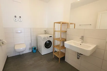 Badezimmer mit WC, Waschplatz und Waschmaschine