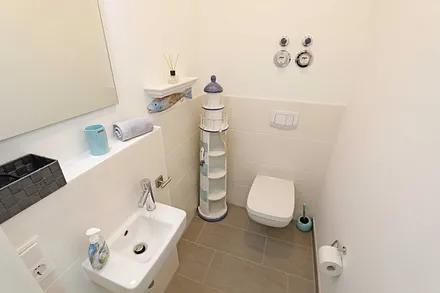 Gästetoilette mit Ablageflächen, Waschtisch und kleinen Fön