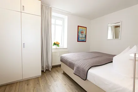 Schlafzimmer mit Doppelbett (2 x 0,90 m x 1,80 m), Nachtischkonsolen und geräumiger Kleiderschrank