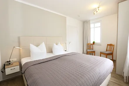 Schlafzimmer mit Doppelbett (2 x 0,90 m x 1,80 m), Nachtischkonsolen und geräumiger Kleiderschrank